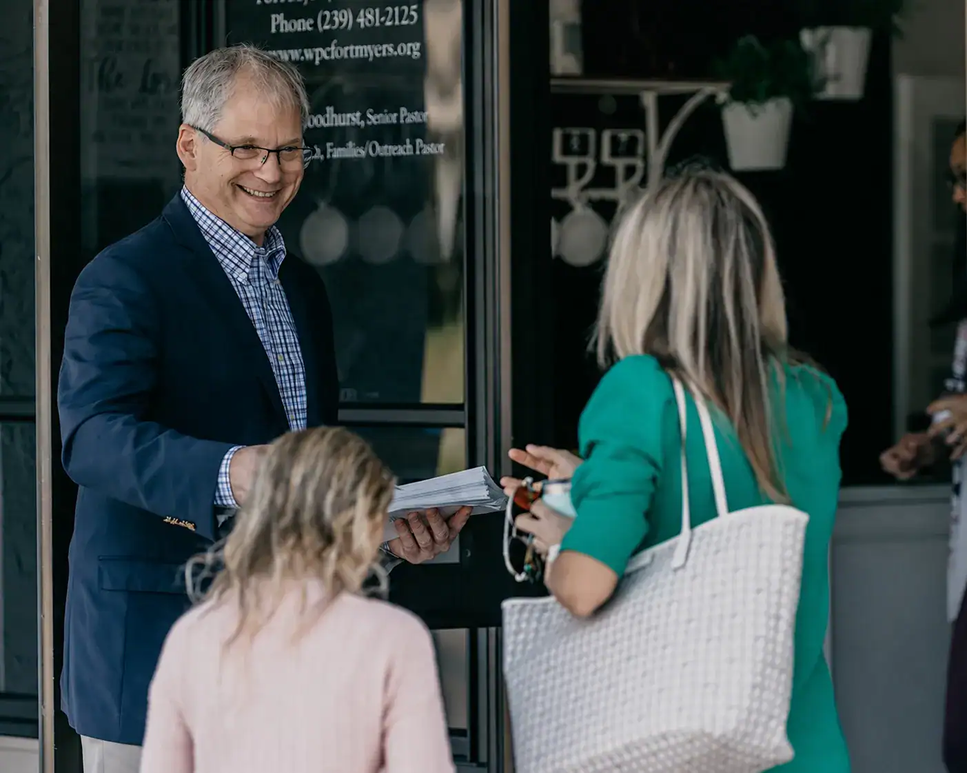 A Westminster greeter welcomes a family at the church’s main entrance